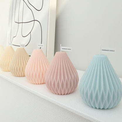 Geometric pastel handmade candles in blue, pink, and beige with a faceted surface