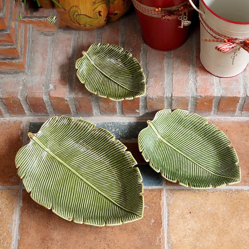 Green leaf-shaped ceramic serving plates with natural vein detailing