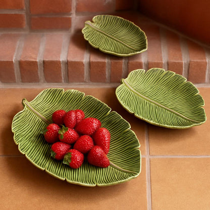Green leaf-shaped ceramic serving plates with natural vein detailing